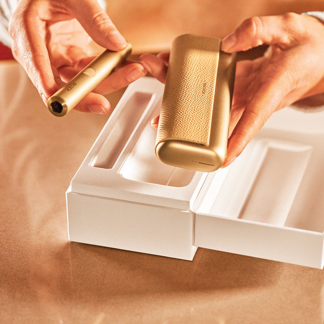 Girl showing a gold IQOS holder
